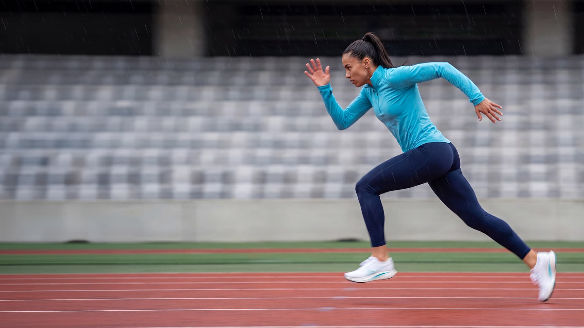 Female track runner sprinting on an outdoor track