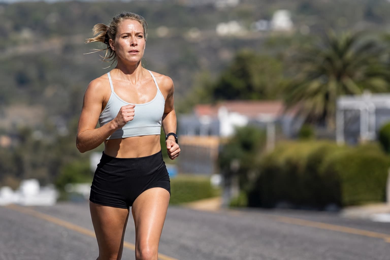 Runner holding a strong, steady pace on an open road.