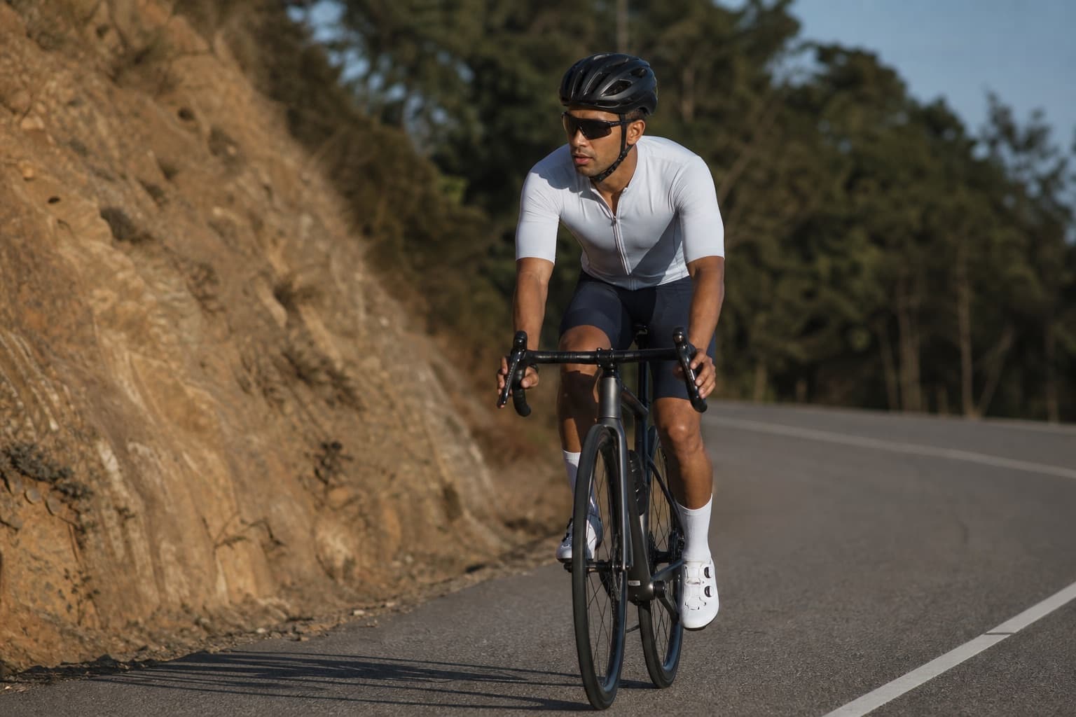 Runner cross training on a road bike along a quiet paved route.