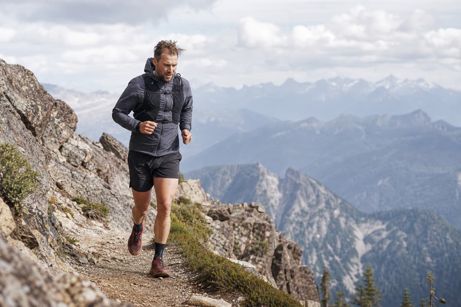 Ultrarunner moving along a rugged mountain trail during a long effort.