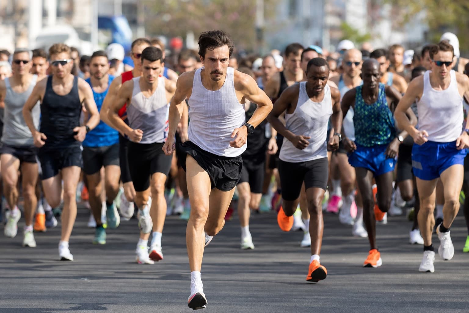 Marathon runner surging ahead of the pack in a crowded race start.