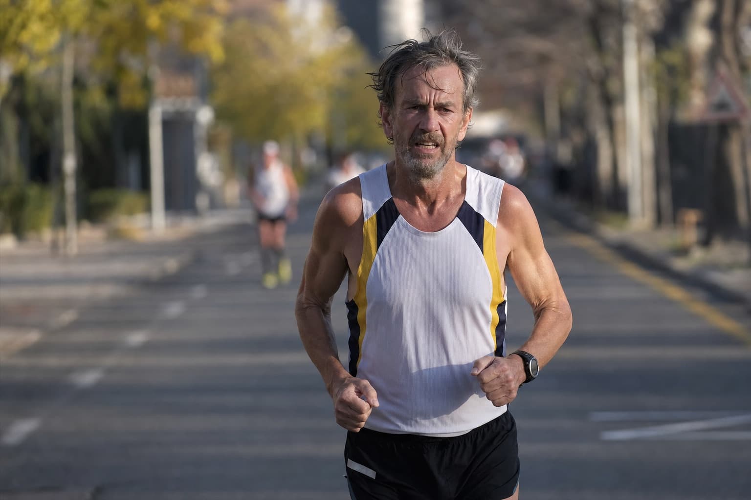 A masters runner grinding through the late miles of a marathon.