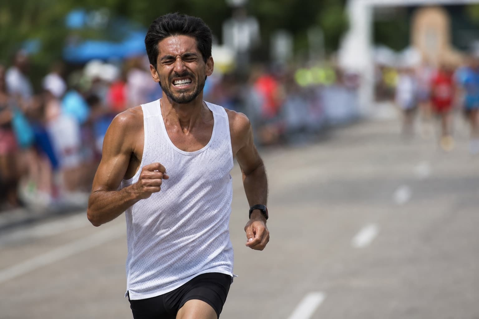 Runner pushing hard in the final stretch of a 10K race.