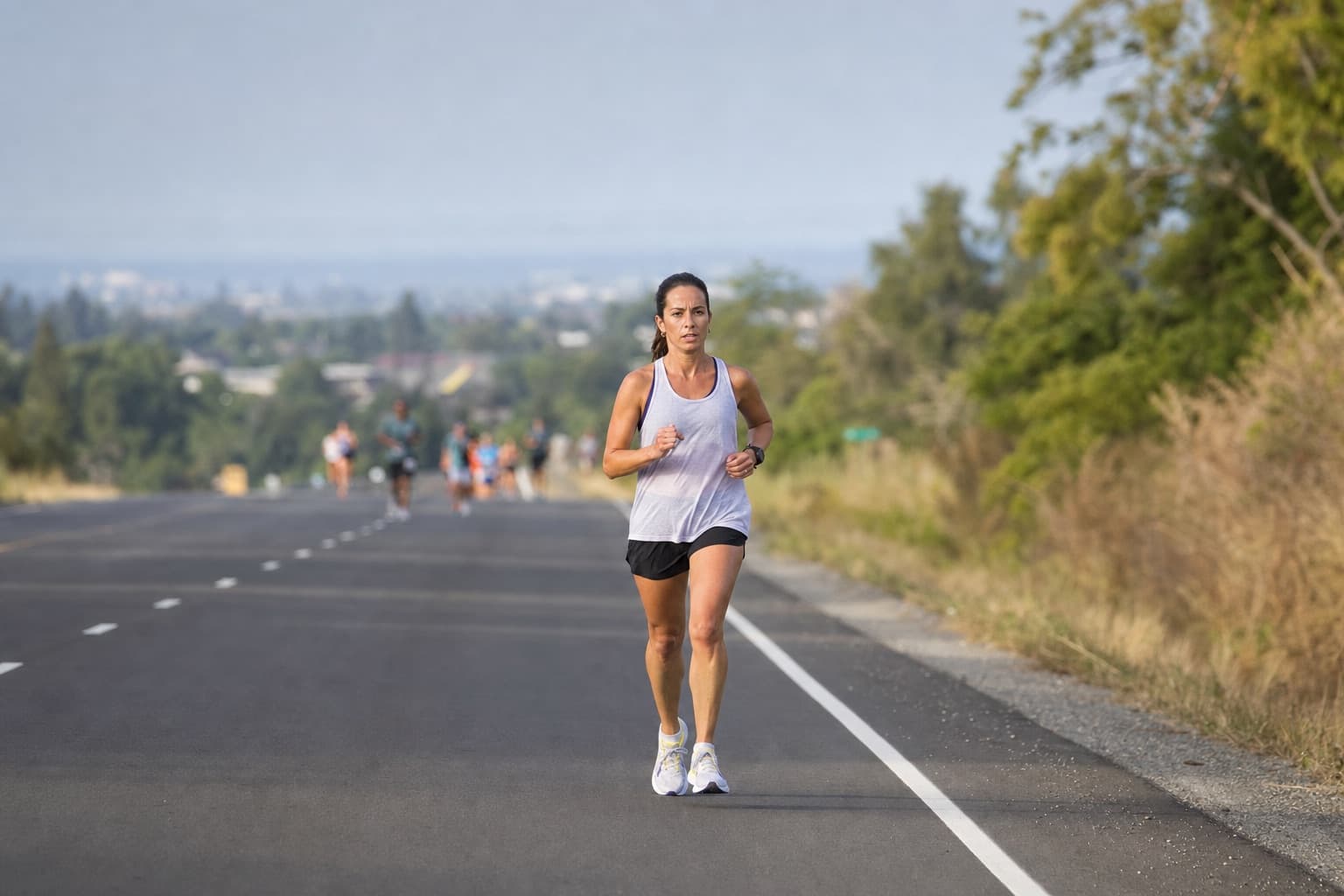 Half marathon runner holding a steady, controlled pace on a long open road.