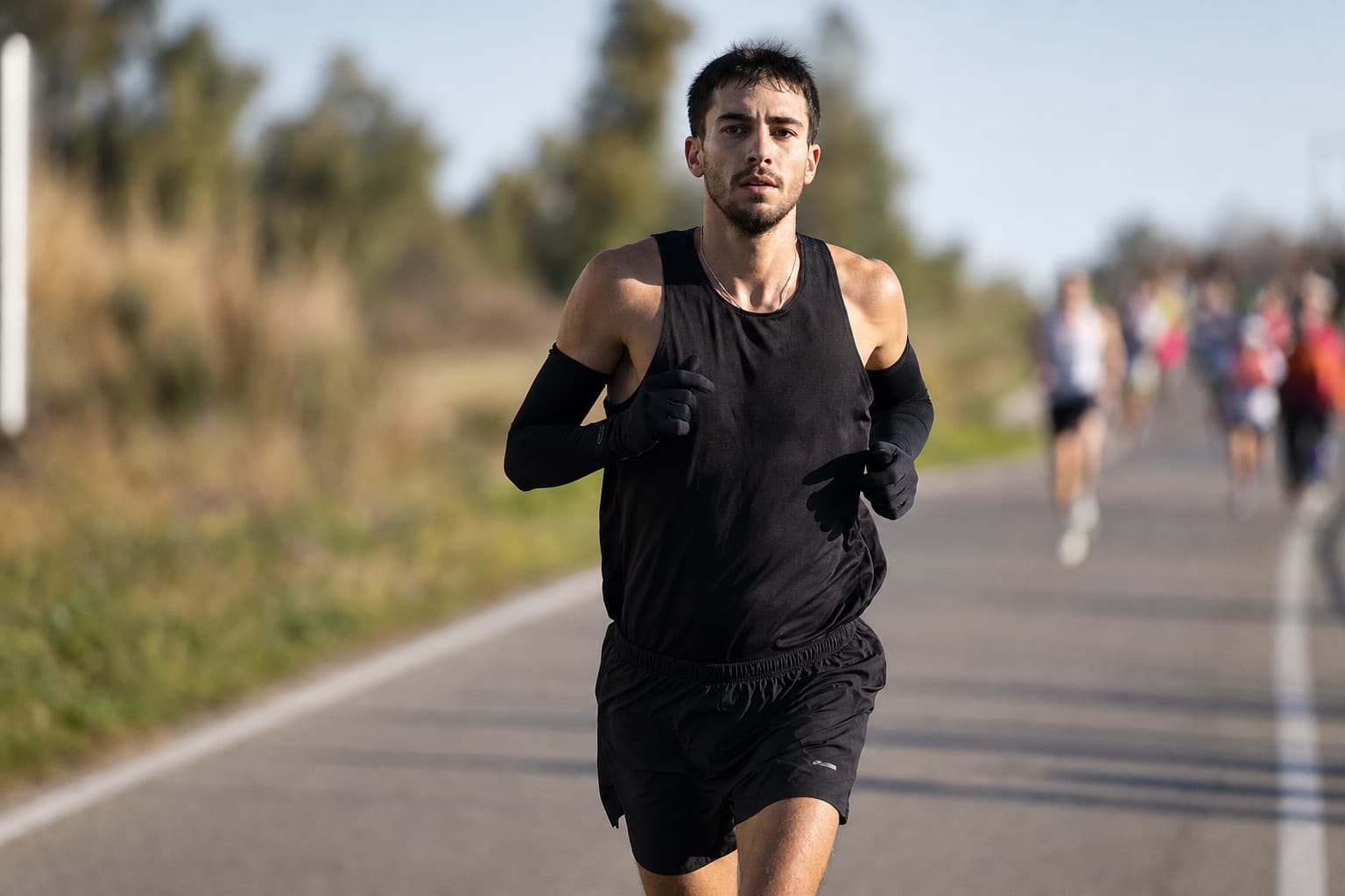 Serious amateur marathoner holding a brisk, controlled goal pace on an open road.