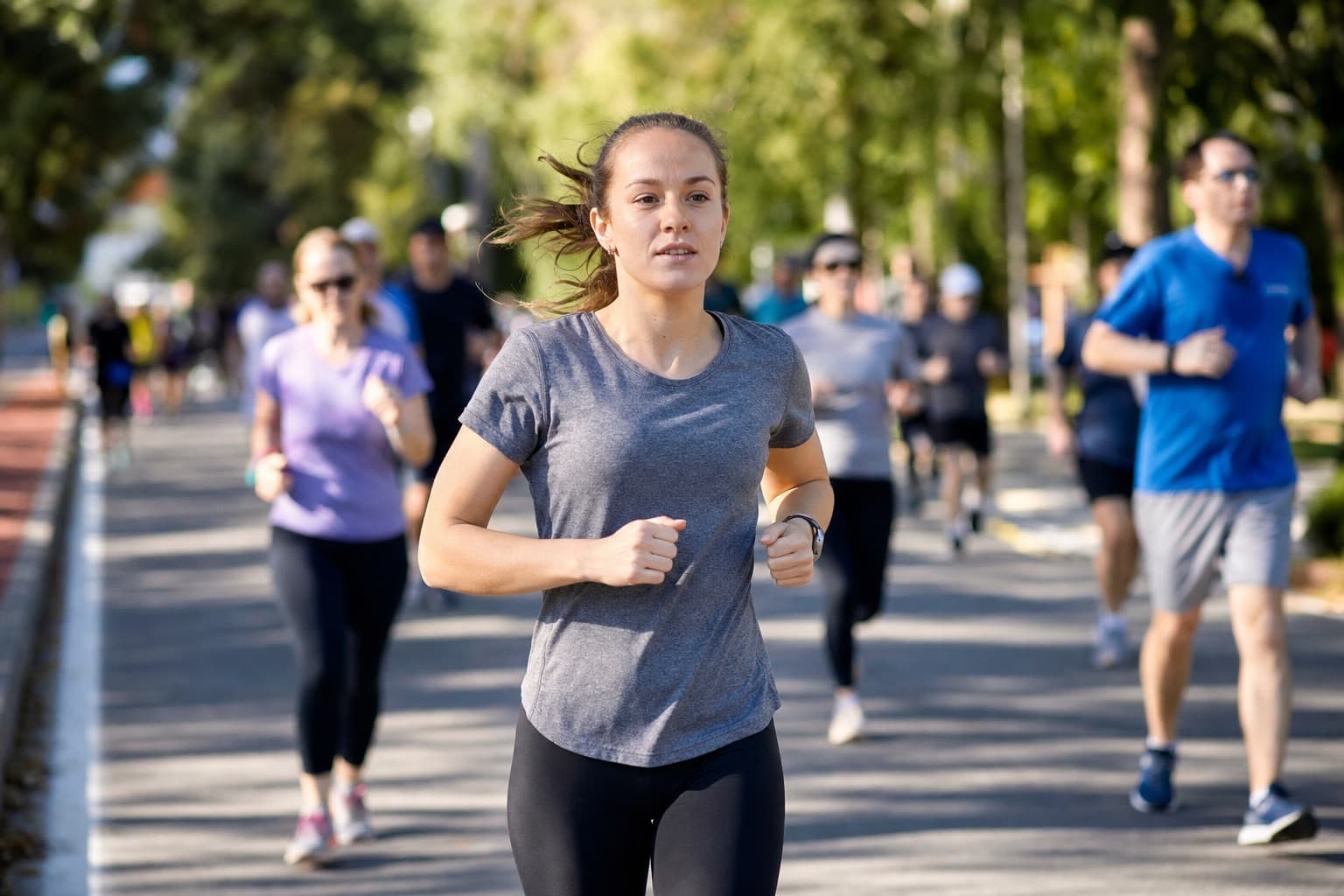 Beginner runner holding a steady even effort on a park path during a 5K.