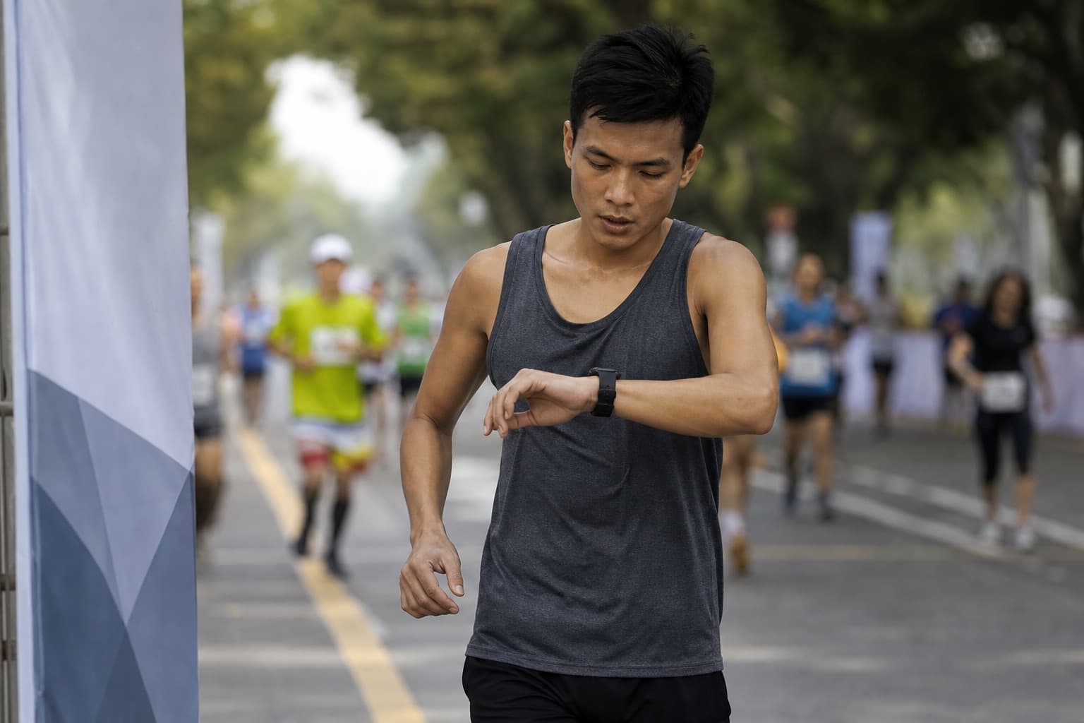 10K runner glancing at a wrist watch to check pace at a checkpoint.