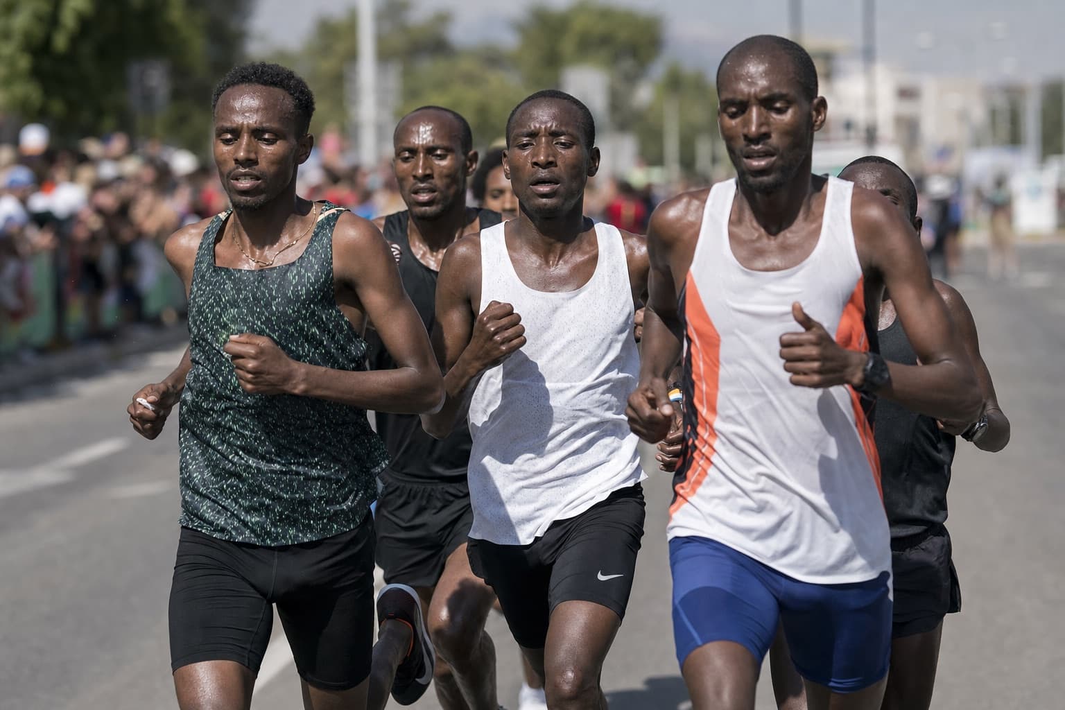 Small lead chase pack of fast half marathon runners racing at a hard pace.