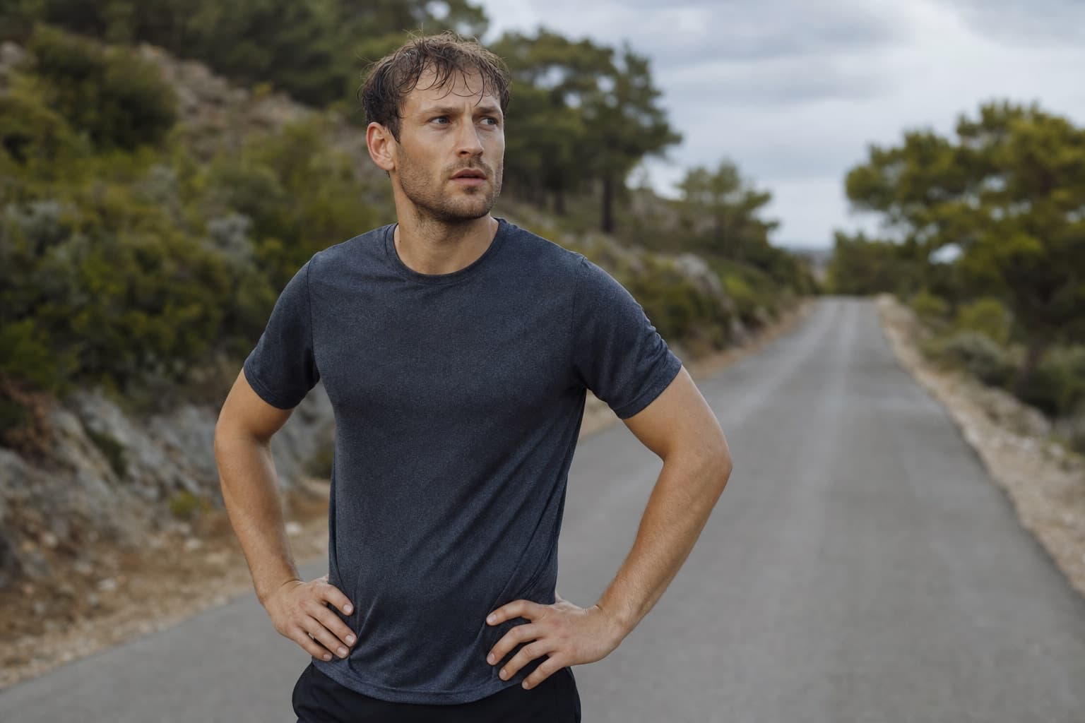 Runner pausing on a road to catch their breath, reflective and self-assessing.