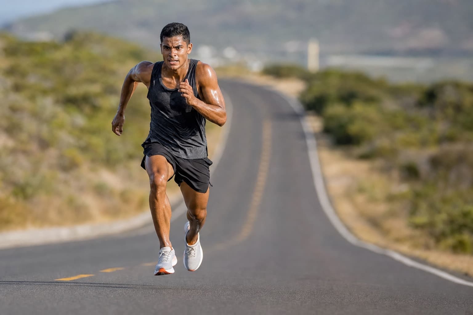Runner driving through a fast, explosive speed session on an open road.