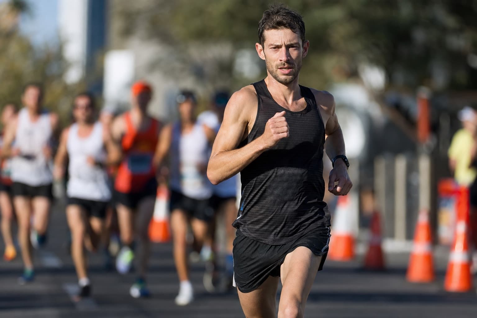 Half marathon runner holding a strong steady pace on a city road.