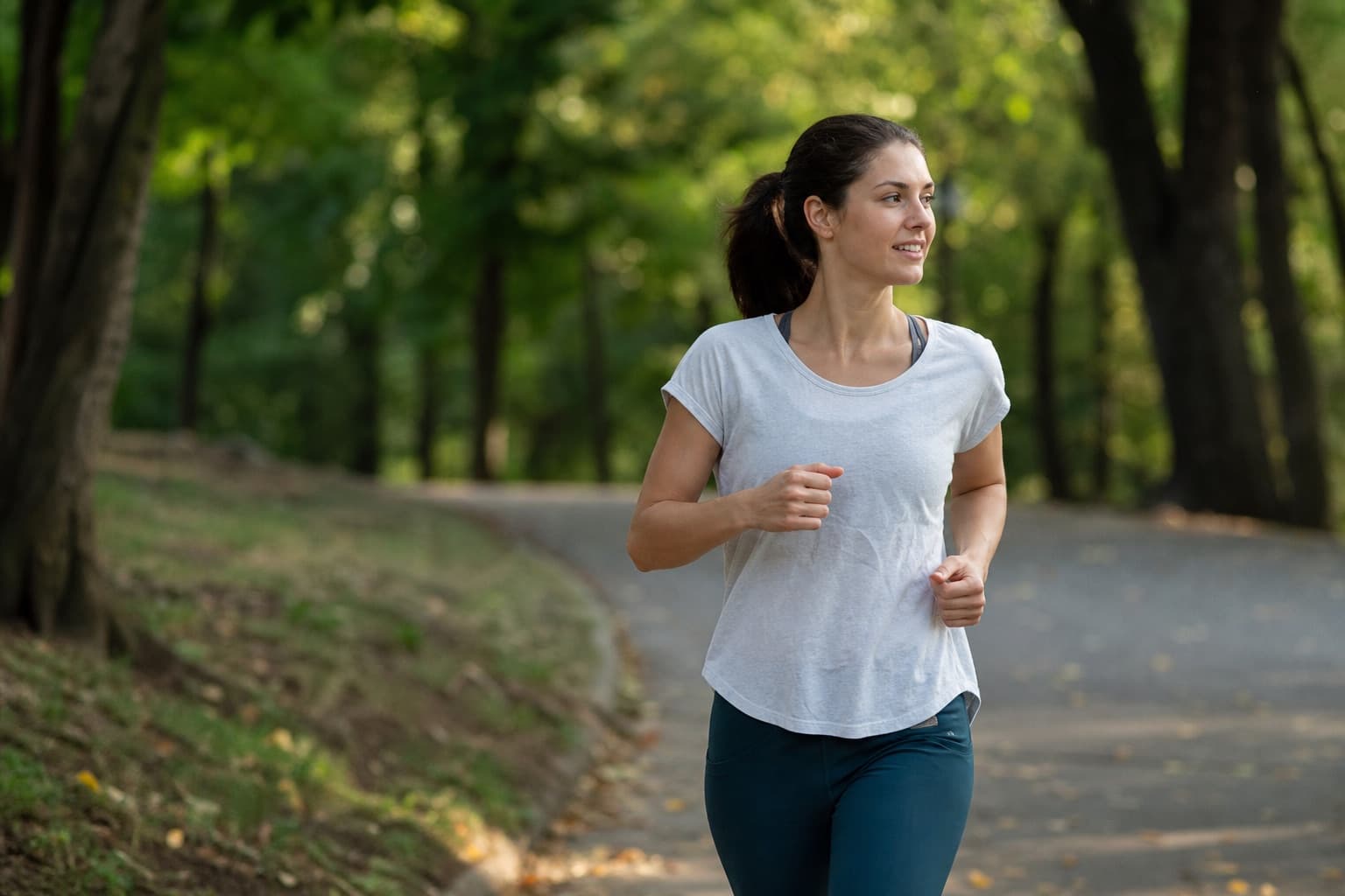 Runner relaxed and at ease on an easy conversational run down a tree-lined path.