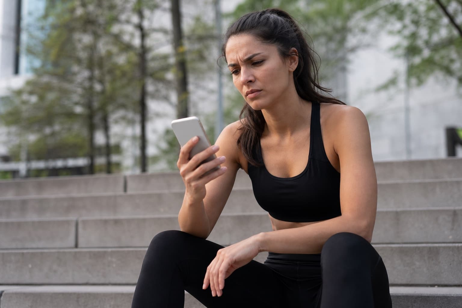 Runner looking skeptically at a race time estimate on a phone after a run.
