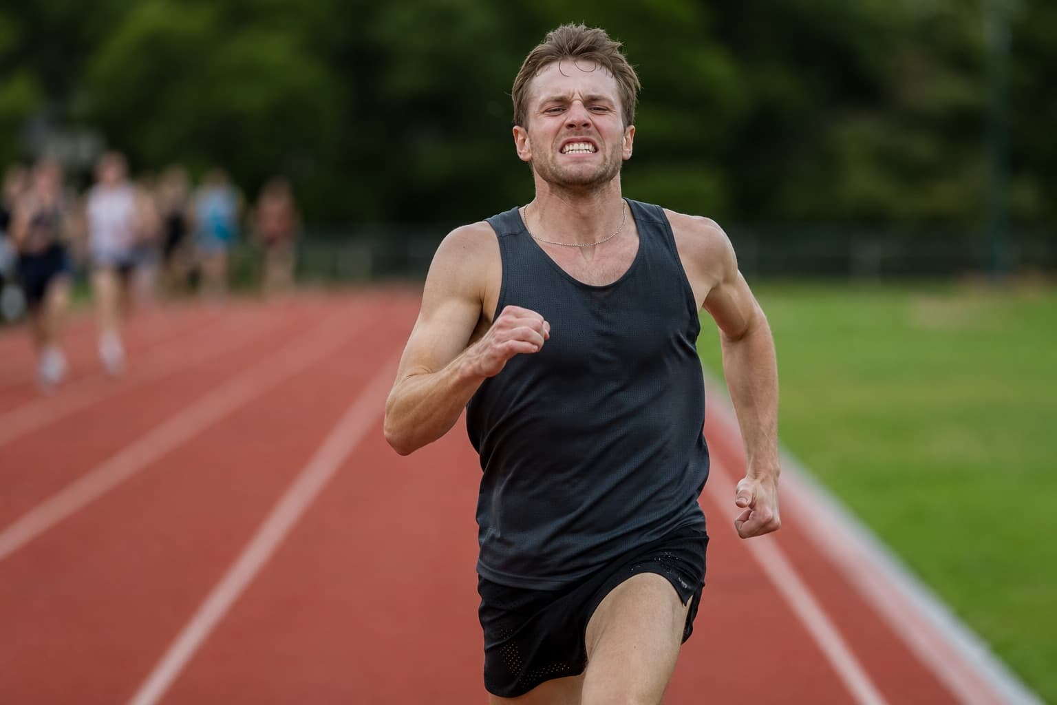 Runner racing a fast, hard 5K effort on an outdoor track.