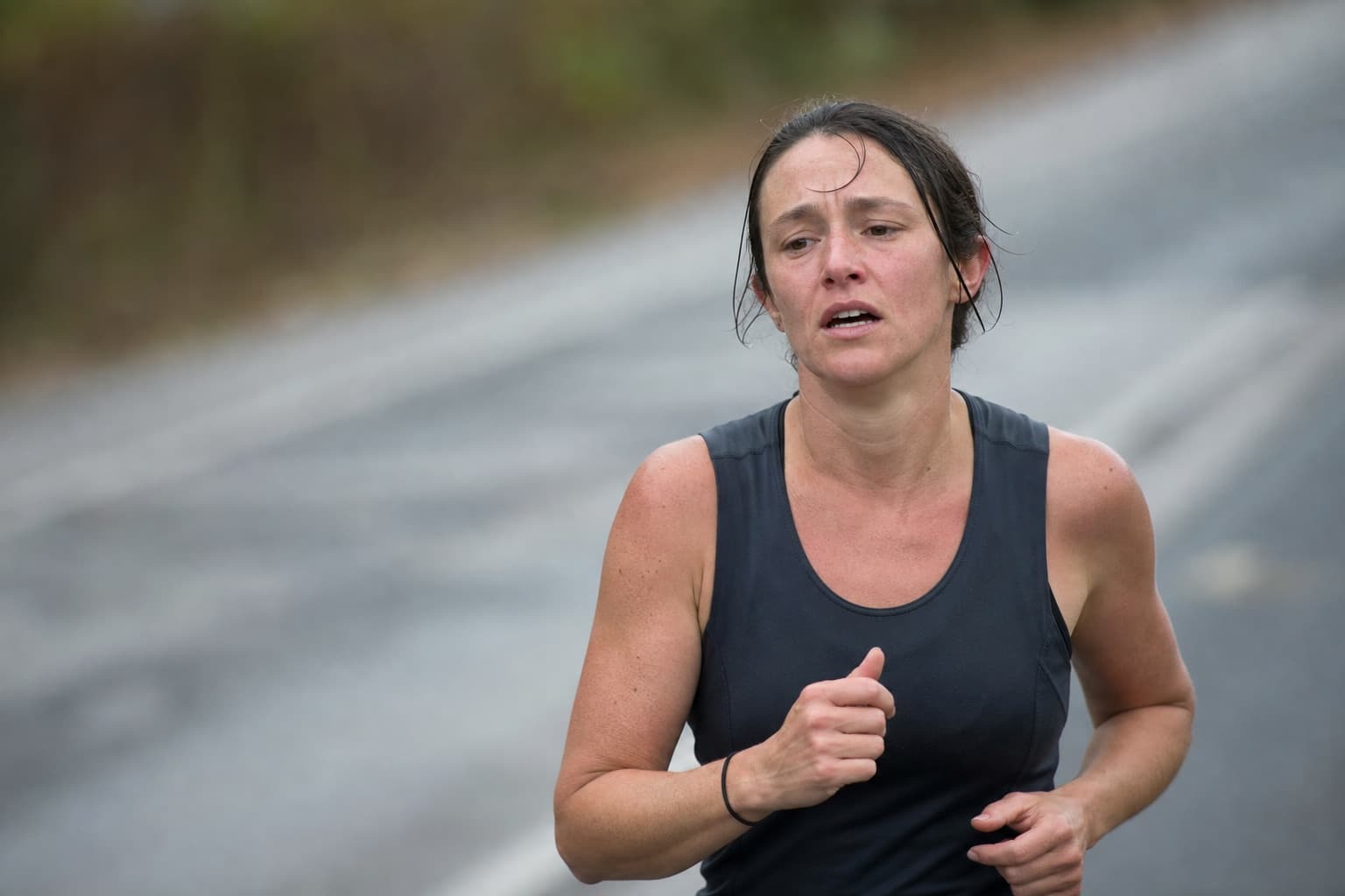 Runner laboring and beginning to tire during the back half of a road race.