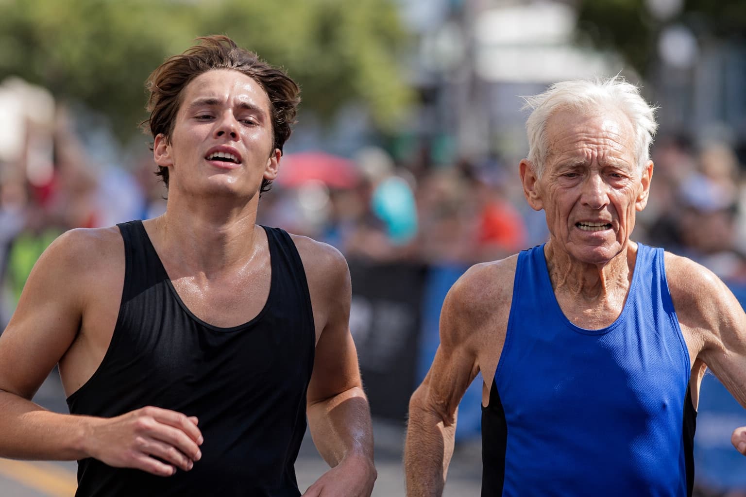 A young runner and an older runner finishing near each other.