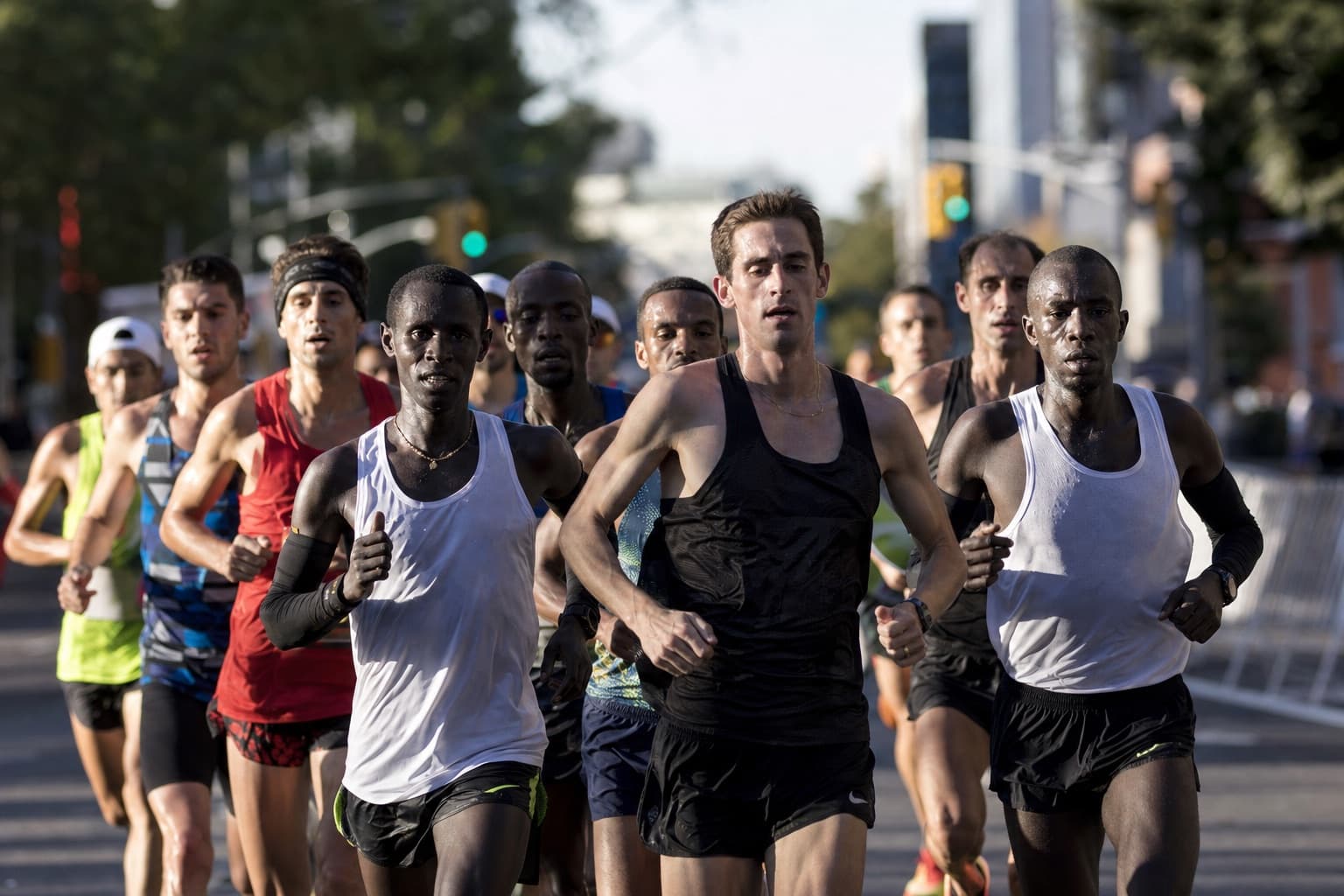 Small pack of marathon runners pushing an even, hard qualifying pace together.