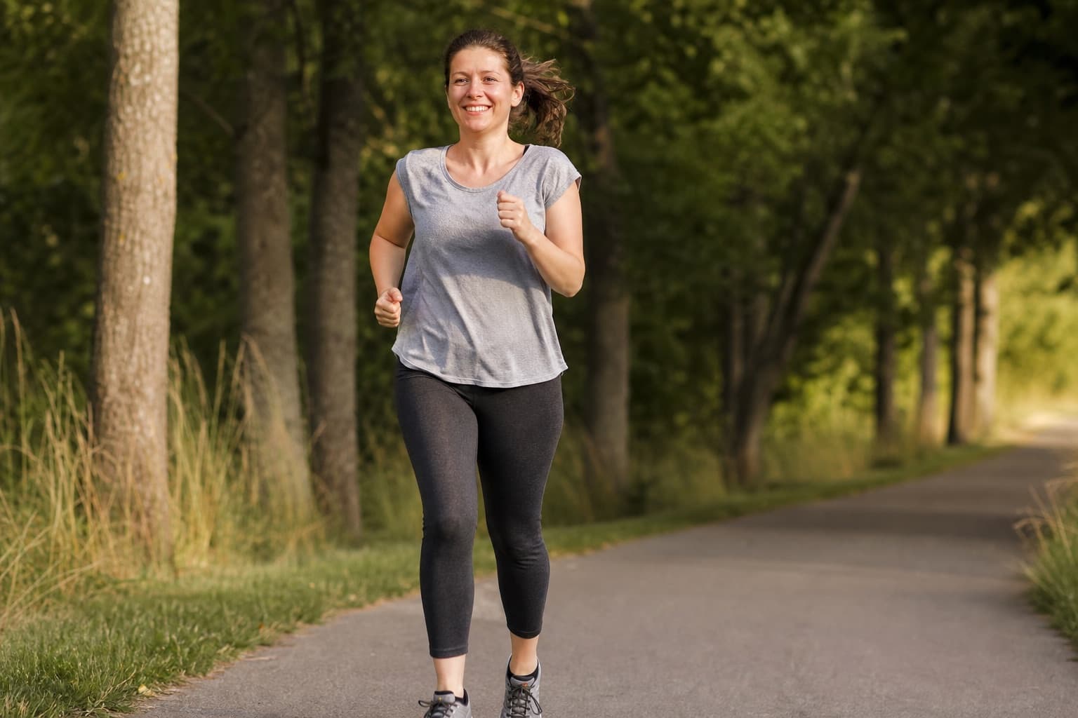 Beginner runner smiling while completing a longer continuous run outdoors.