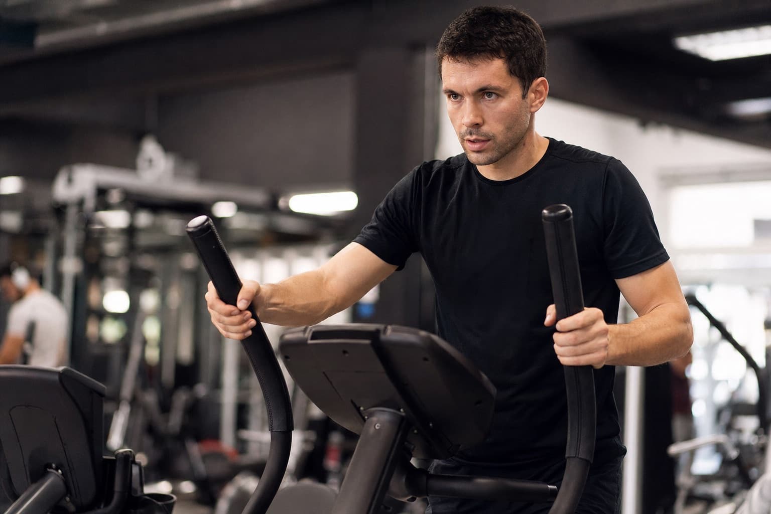 Runner using an elliptical machine in a gym as a running substitute.