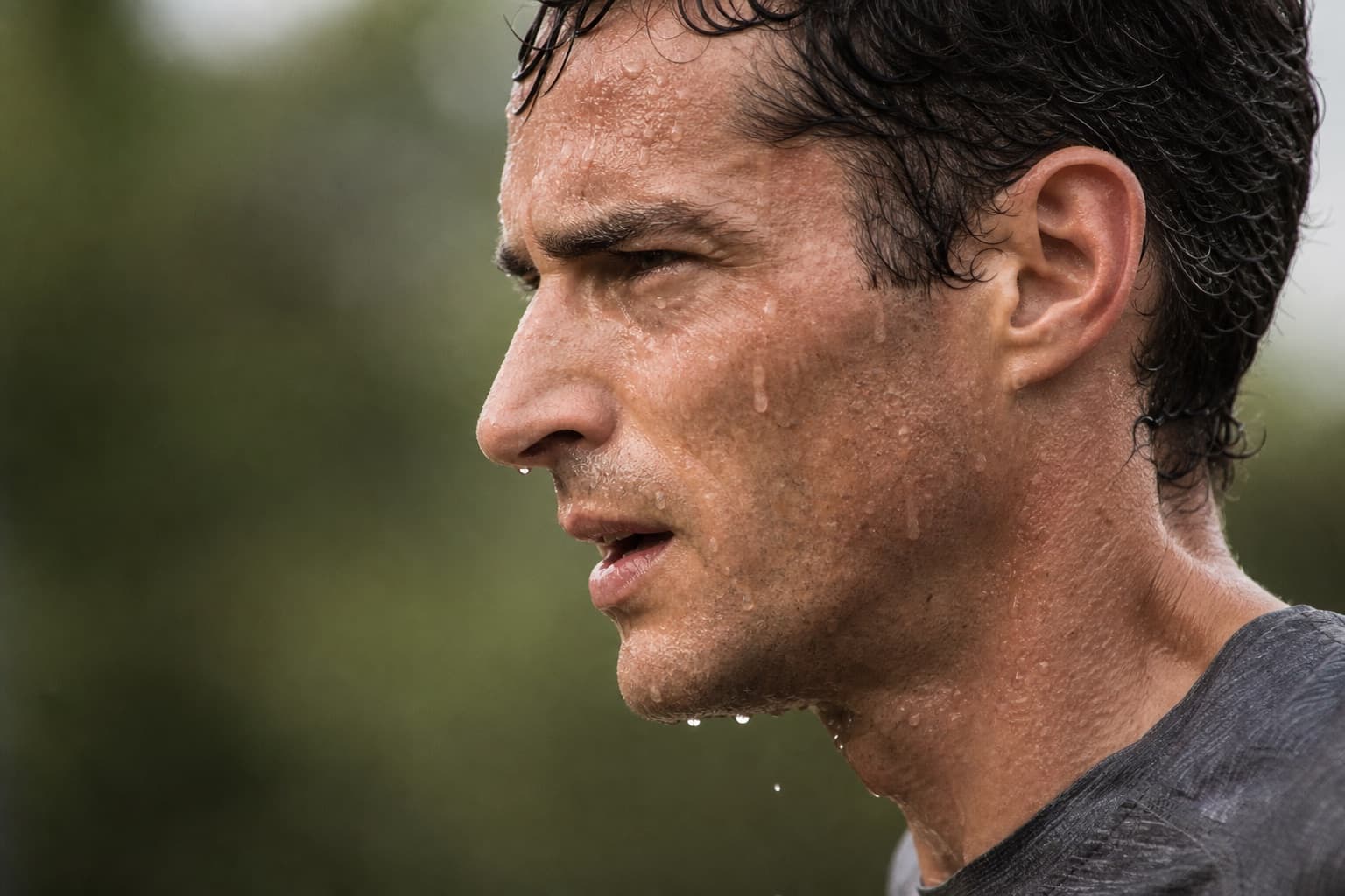 Close-up of sweat dripping down a runner's face in humid air.