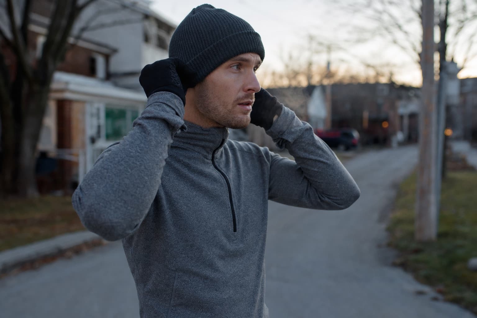 Runner pulling on gloves and a hat before a cold-weather run.