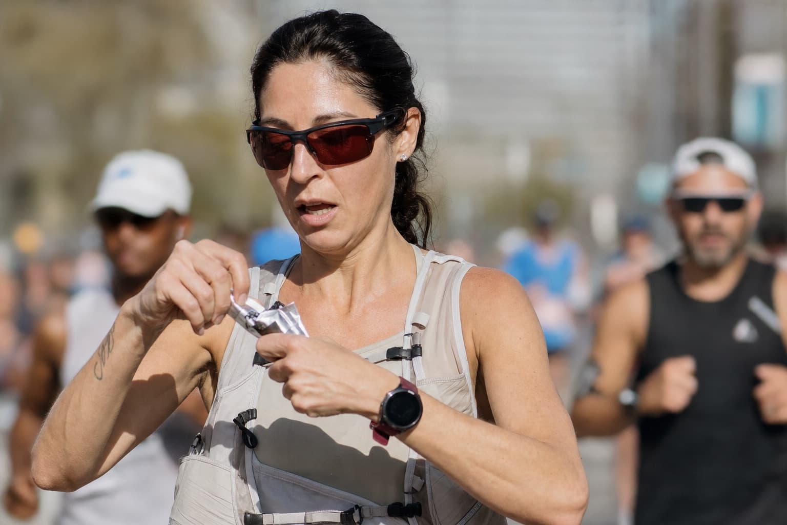 Marathon runner taking an energy gel during the middle of a race.