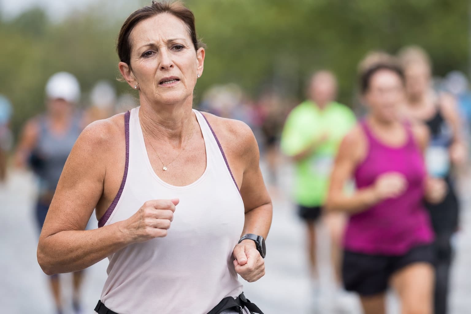 A woman runner in her fifties holding pace deep into a half marathon.