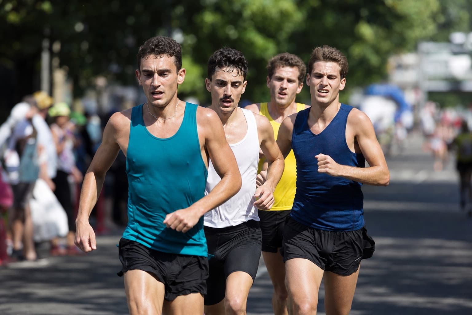 Small chase pack of runners locked together at a hard 5K race pace.