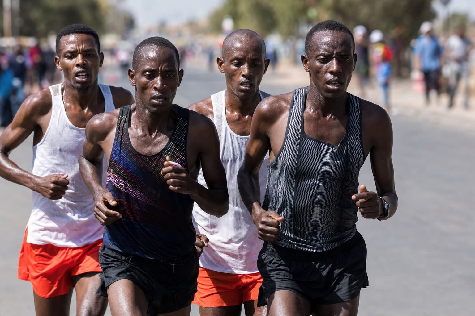 Small front-of-pack group of marathoners pushing hard near the 30-kilometer mark.