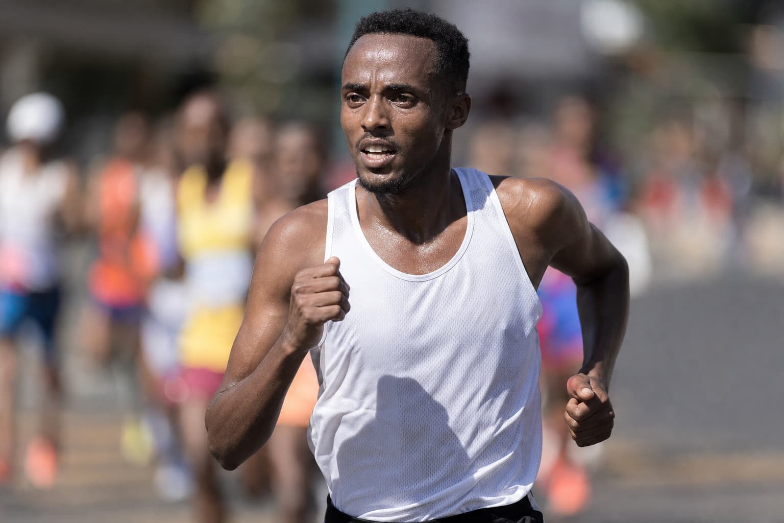 Runner pushing a fast controlled effort during a road race.