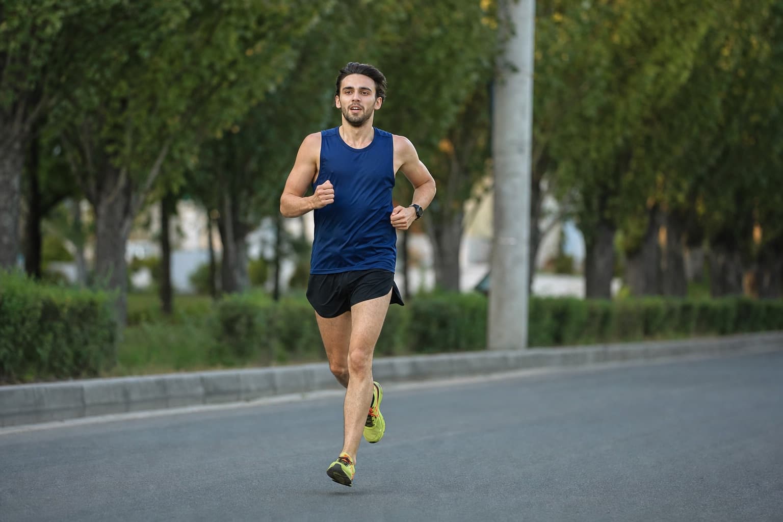 Runner striding easily along smooth, flat paved road.