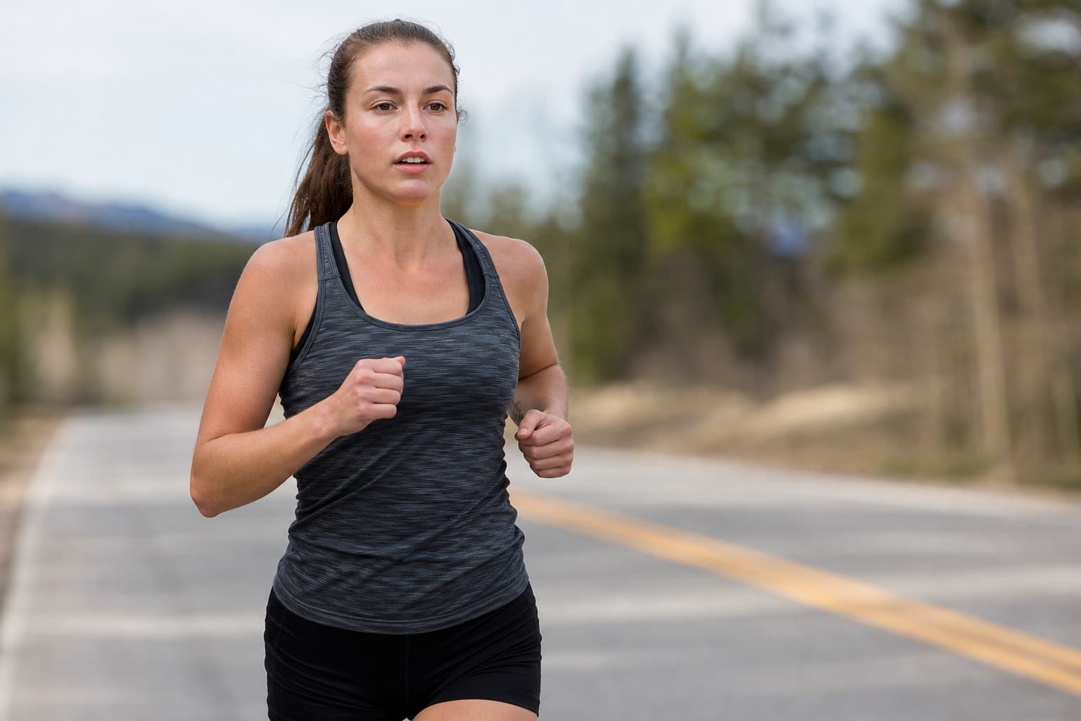 Runner moving at an easy outdoor pace along an open paved road.