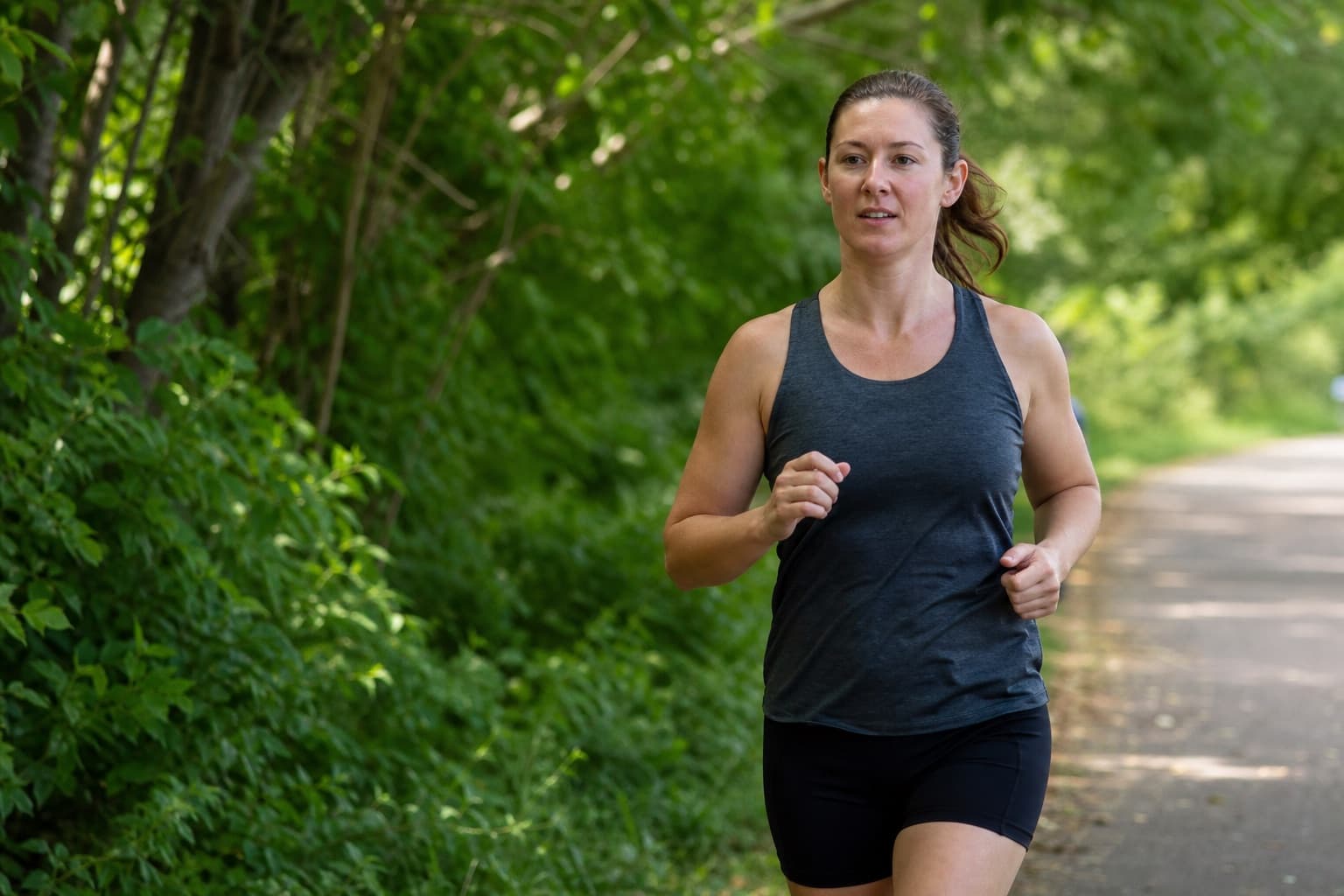Runner jogging at an easy conversational pace on a quiet path.