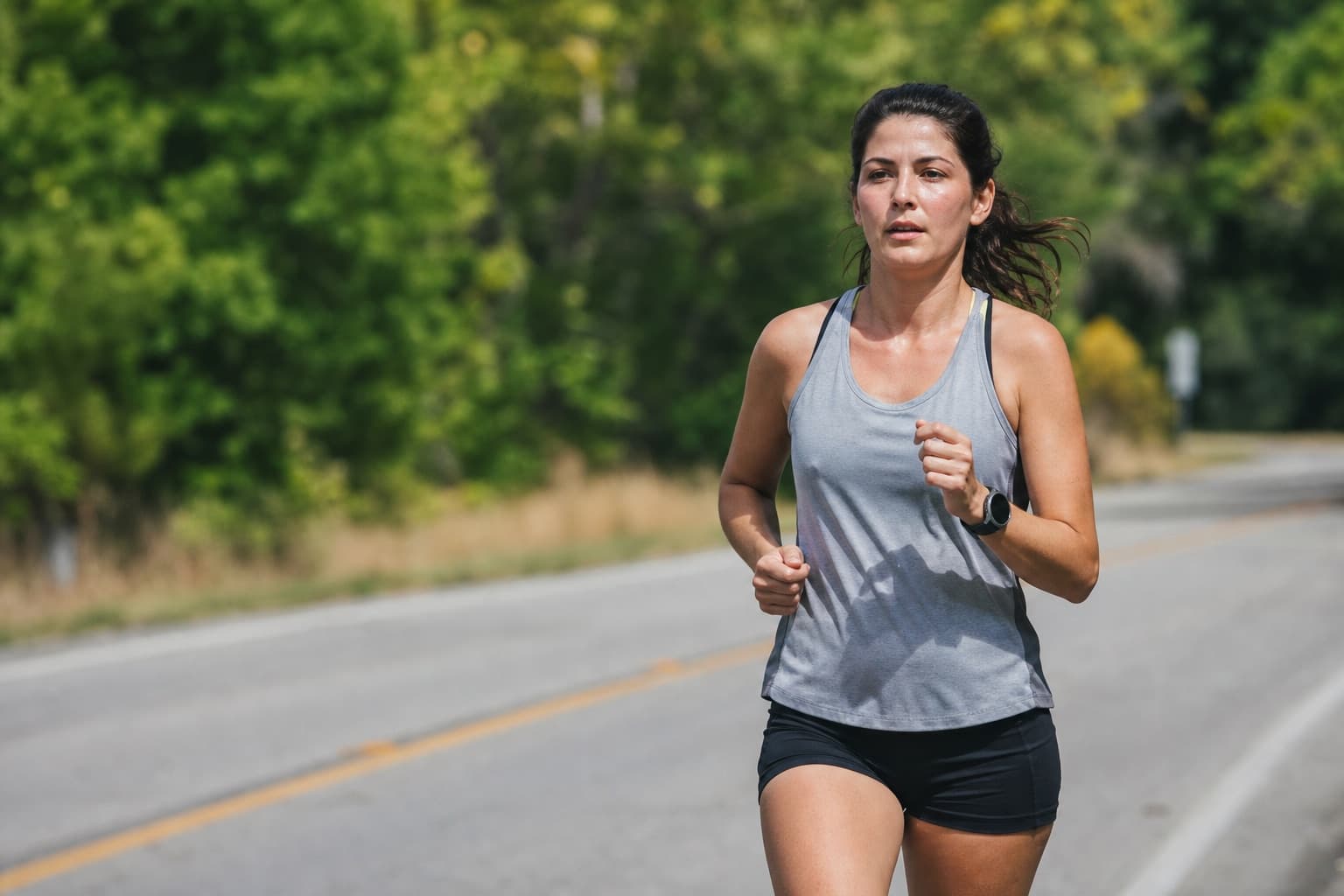 Relatable everyday runner holding a steady comfortable pace on a road.